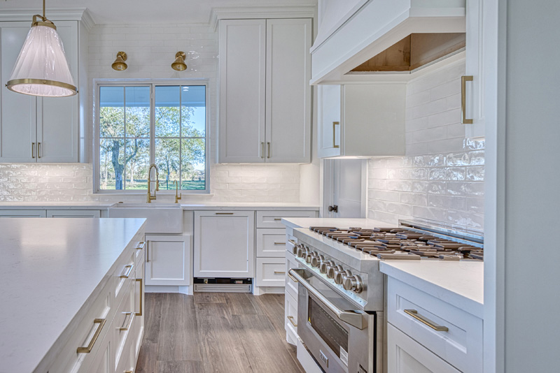 White custom designed and built cabinets with gold hardware and quartz countertops